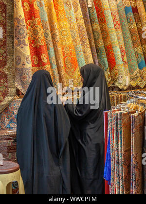 Deux femmes musulmanes l'achat des tissus dans un bazar de Téhéran, Iran Banque D'Images