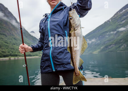 Pêche à la femme sur la canne à pêche spinning en Norvège. La pêche en Norvège est une façon d'embrasser le mode de vie local. D'innombrables lacs et rivières et d'une ampleur Banque D'Images