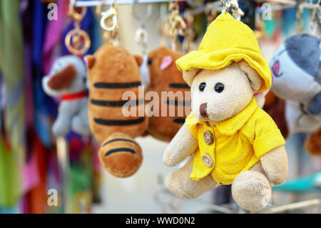Un petit ours en peluche dans une veste jaune et un chapeau. Banque D'Images
