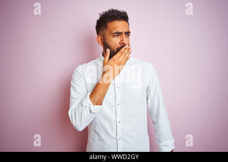 Young indian businessman wearing shirt debout sur fond rose isolé ennuyer le bâillement fatigué couvrant la bouche avec la main. Et le sommeil agité Banque D'Images