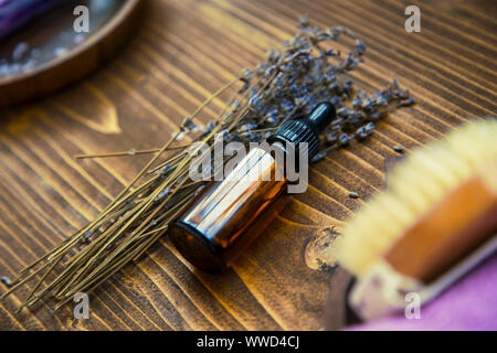L'huile de lavande , accueil spa avec une bouteille d'huile essentielle de lavande et de fleurs sur fond de bois rustique, spa still life mise Banque D'Images