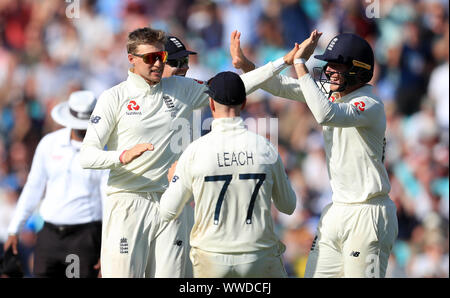 Joe l'Angleterre (à gauche) célèbre racine en tenant le guichet de l'Australie en Mitchell Marsh pendant quatre jours de la cinquième test match à l'Ovale de Kia, Londres. Banque D'Images