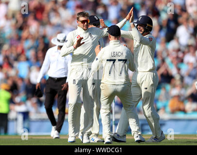 Joe l'Angleterre (à gauche) célèbre racine en tenant le guichet de l'Australie en Mitchell Marsh pendant quatre jours de la cinquième test match à l'Ovale de Kia, Londres. Banque D'Images