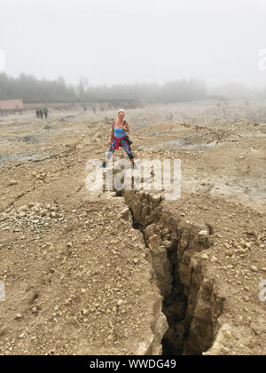 Femme à cheval sur une crevasse post tremblement de terre à une mine à ciel ouvert, la Lituanie Banque D'Images