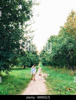 Femme jouant avec son chien sur une promenade matinale, Bélarus Banque D'Images