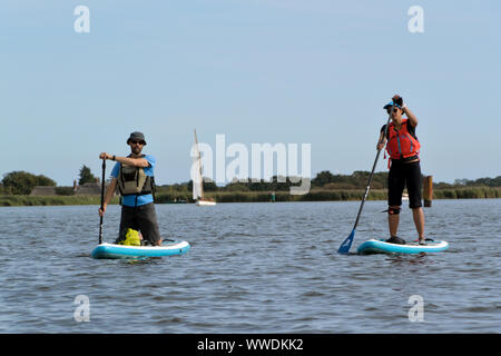 Se lever sur paddleboarders Hickling Broad, Norfolk Broads, Parc National Banque D'Images