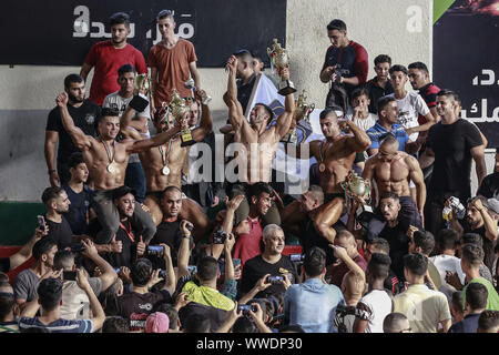 La ville de Gaza, Territoires palestiniens. 15 Sep, 2019. Les bodybuilders palestiniens célébrer comme ils détient trophées de la remise en forme et de musculation championnat. Credit : Mohammed Talatene/dpa/Alamy Live News Banque D'Images