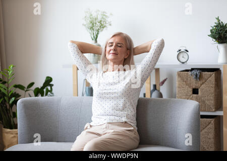 Femme plus détendue heureux assis penché en arrière sur la table Banque D'Images