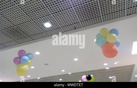 Grille perforée et plafond plafond plâtre peint en blanc pour les joints d'un magasin de détail au cours de la vente et du festival décoré par des ballons suspendus Banque D'Images