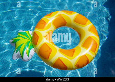 Ananas gonflable ring floating in swimming pool Banque D'Images