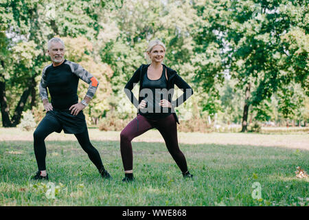 Gai, sportif et de la sportive mature faisant se jette exercises in park Banque D'Images