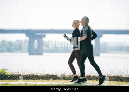 Sportif et sportive mature le long de Riverside Park Banque D'Images
