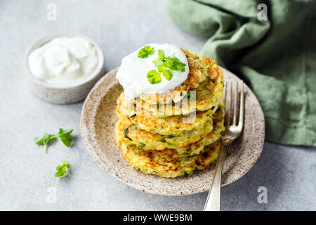 Courgettes végétariennes crêpes ou beignets à la crème sure pile sur la plaque. Apéritif ou un en-cas sains Banque D'Images