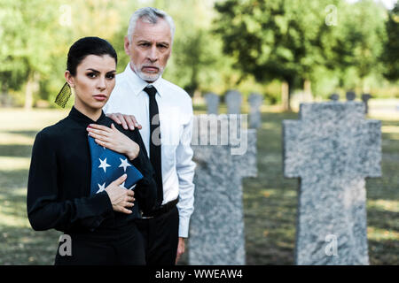 Portrait de femme avec drapeau américain près de l'homme barbu sur funeral Banque D'Images