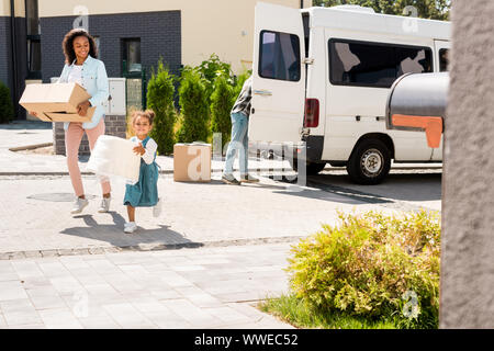 Sur toute la longueur de l'african american mother and daughter fonctionnant en maison avec une certaine substance Banque D'Images