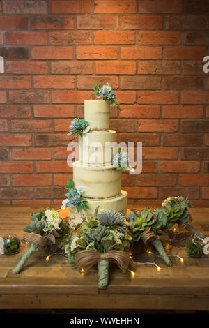Gâteau de mariage à quatre niveaux, avec glaçage buttercream crème et les succulentes décorer le gâteau, gâteau de mariage Banque D'Images