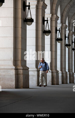 USA Washington DC La gare Union Station de Train de banlieue d'une randonnée avec un sac à dos et au casque et le téléphone dans l'arcade Banque D'Images