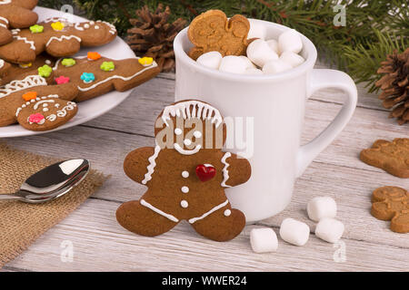 Gingerbread cookies et chocolat chaud sur une table en bois. En arrière-plan de sapin. Concept de vacances de Noël. Banque D'Images