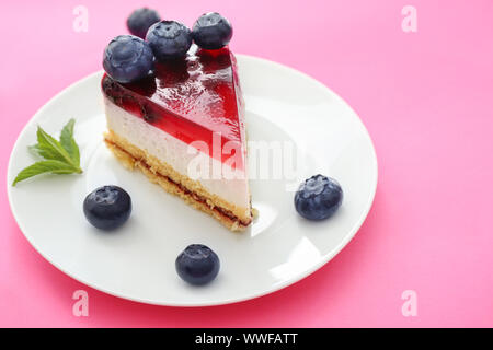 Morceau de gâteau au fromage et bleuets délicieux sur un fond de couleur Banque D'Images