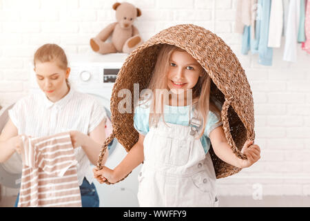 Femme et sa petite fille faire la lessive à la maison Banque D'Images