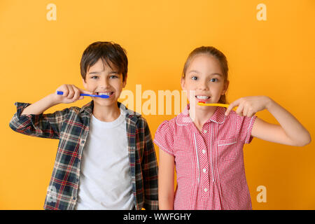 Cute little children nettoyer les dents contre l'arrière-plan couleur Banque D'Images