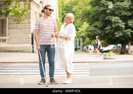 Jeune homme aveugle avec la mère la marche à l'extérieur Banque D'Images