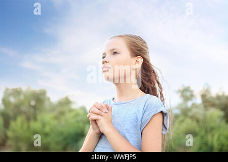 Petite fille priant à Dieu à l'extérieur Banque D'Images