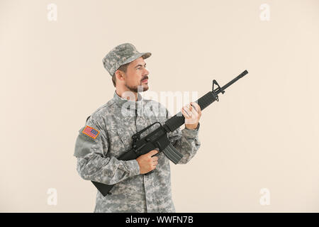 Soldat avec fusil d'assaut sur fond clair Banque D'Images