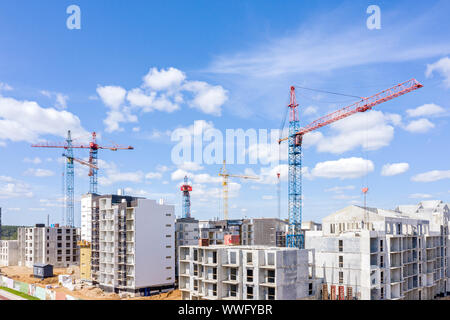 Haut bâtiment moderne de grues à tour près de logements en construction. Vue aérienne Banque D'Images