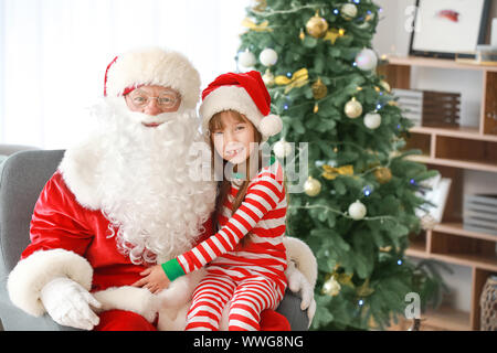 Le Père Noël et petite fille dans la salle décorée pour Noël Banque D'Images