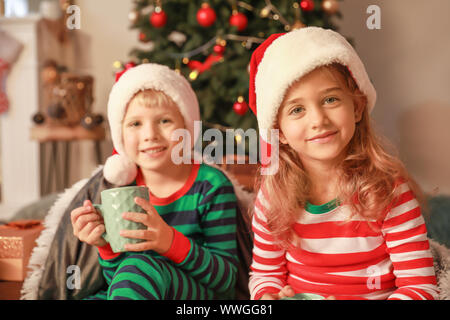 Enfants mignon petit chapeau au Père Noël la veille de Noël à la maison Banque D'Images