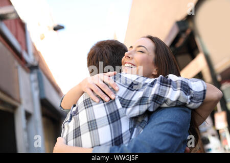 Joyful couple hugging in la rue d'une vieille ville après une rencontre Banque D'Images