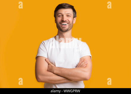 Happy Middle aged Man Crossing Main sur fond jaune Banque D'Images