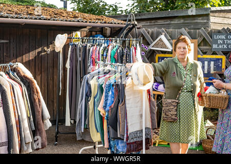 Femme détaillant vendant des années 40 vintage style vêtements pendant le week-end annuel de la quarantaine à Sheringham, Norfolk Banque D'Images