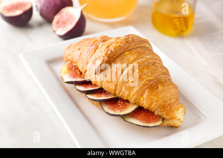 Plaque avec sweet croissant et de figue tranches sur le tableau Banque D'Images