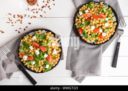 Salade de pois chiches savoureux avec les plaques sur la table Banque D'Images