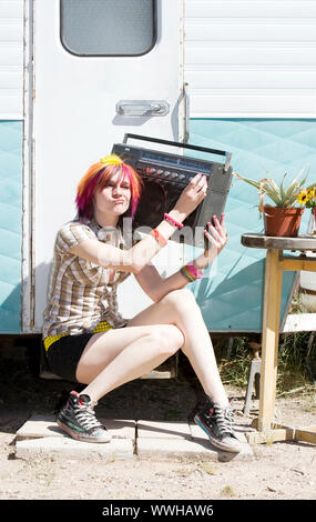 Punk fille avec des cheveux de couleur vive assis sur la remorque l'étape man Banque D'Images