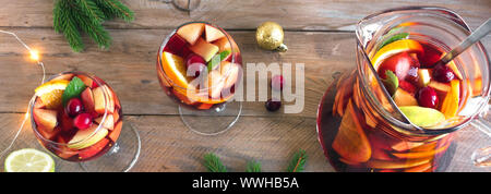 Sangria ou punch de Noël dans les verres et pichet. Vin rouge sangria aux fruits faits maison et décoration de fête de Noël sur fond de bois, d'un bandeau. Banque D'Images