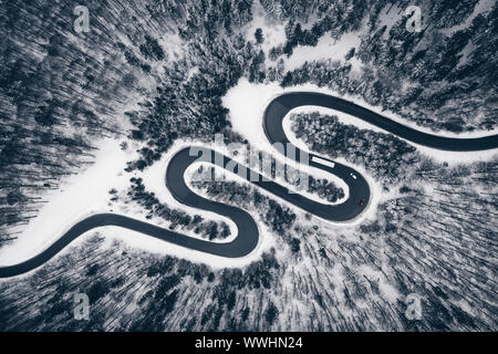 Route sinueuse dans une forêt couverte de neige Banque D'Images