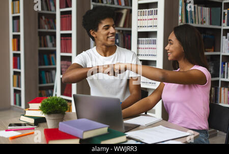Couple d'étudiants afro cheering up les uns les autres avant d'étudier Banque D'Images