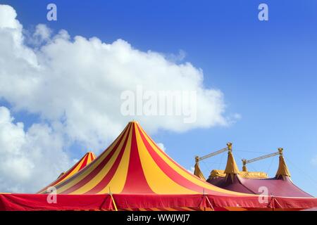 Tente de cirque rouge orange et jaune motif stripped blue sky Banque D'Images