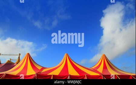 Tente de cirque rouge orange et jaune motif stripped blue sky Banque D'Images