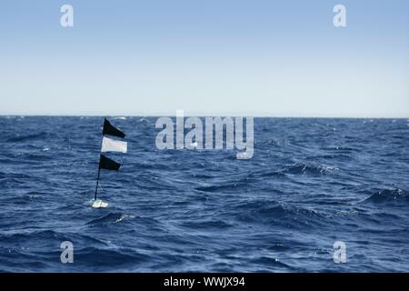 L'océan bleu avec le drapeau à la palangre flottante pêche phare en Espagne Banque D'Images
