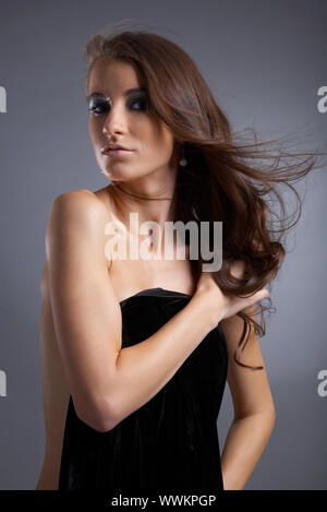Séduisant jeune modèle couvre sa poitrine avec tissu noir Banque D'Images