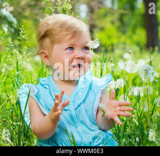 Clouse-up portrait joli petite fille assise dans l'herbe dans le parc Banque D'Images