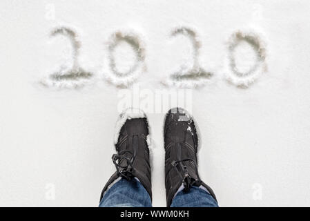 2020 écrit dans la neige avec des selfies bottes, carte de voeux nouvel an hiver Banque D'Images