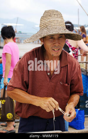 HONG KONG - SEPT 12, un pêcheur traditionnel chinois fait net sur l'île de Lamma, Hong Kong le 12 septembre 2009. Banque D'Images