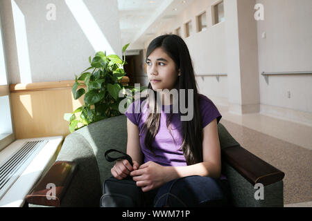 Jeune fille de l'adolescence en salle d'attente, l'expression inquiète Banque D'Images