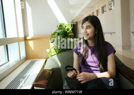 Jeune adolescent assis en salle d'attente du médecin Banque D'Images