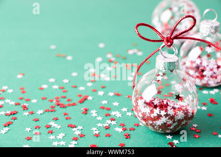 Close up of transparent Chritmas avec boules étoile scintiller à l'intérieur sur fond bleu turquoise Banque D'Images
